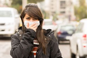 portrait of young girl walking wearing a mask in the city street concept of  pollution